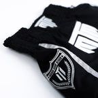 Fighter wearing MTM Essentials Muay Thai Shorts in black, in action