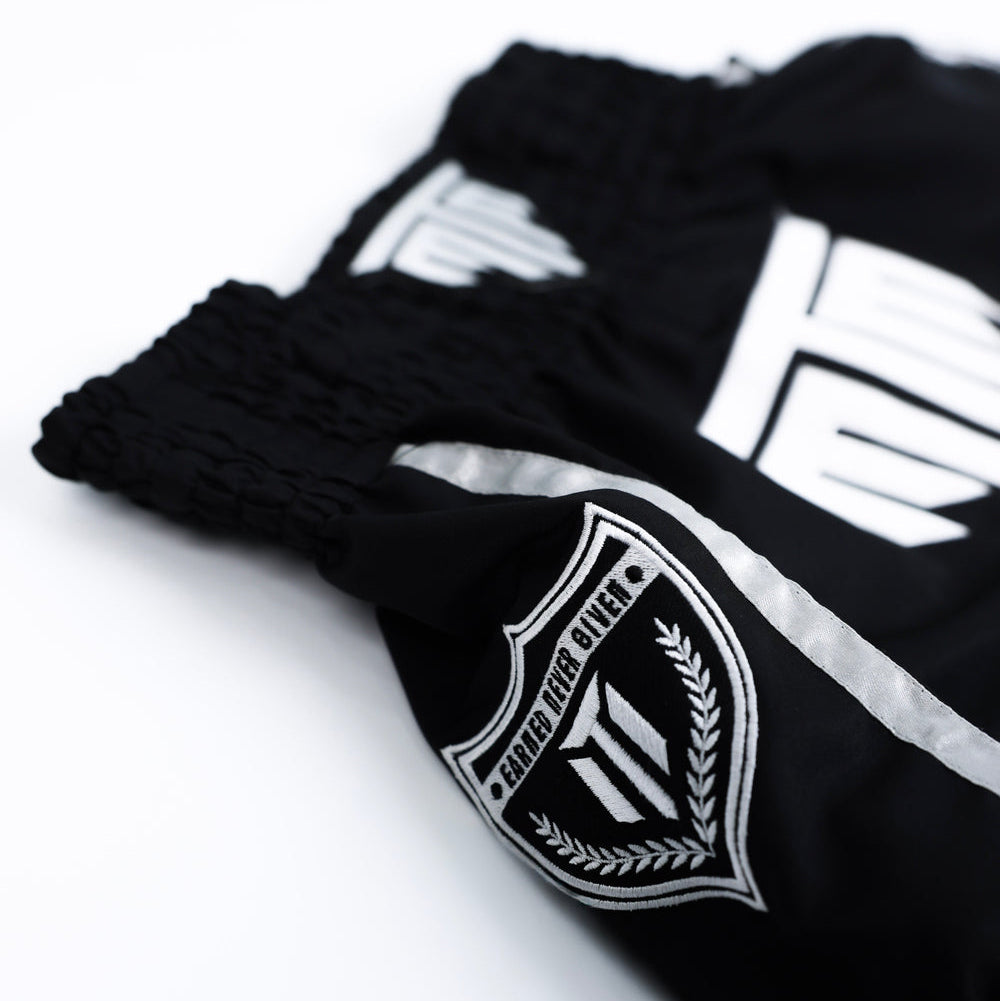 Fighter wearing MTM Essentials Muay Thai Shorts in black, in action