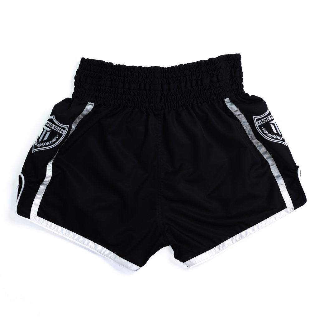 Fighter wearing MTM Essentials Muay Thai Shorts in black, side view