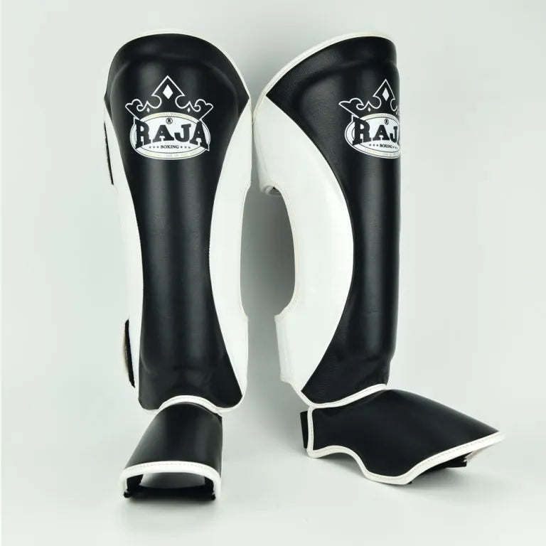 Raja Boxing Muay Thai Style Shin Guards in black and white, front view