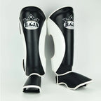 Raja Boxing Muay Thai Style Shin Guards in black and white, front view