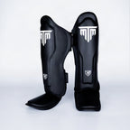 MTM Sport VX Shin Guards in black, angled view showing straps on white background