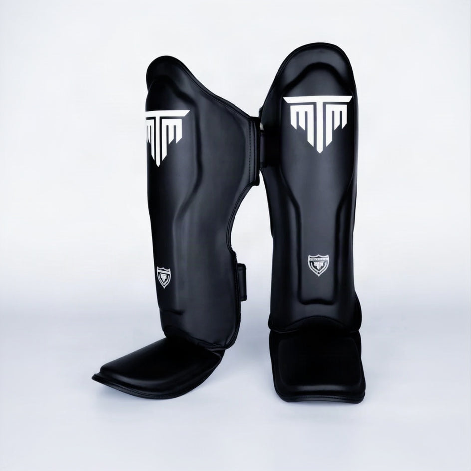 MTM Sport VX Shin Guards in black, angled view showing straps on white background