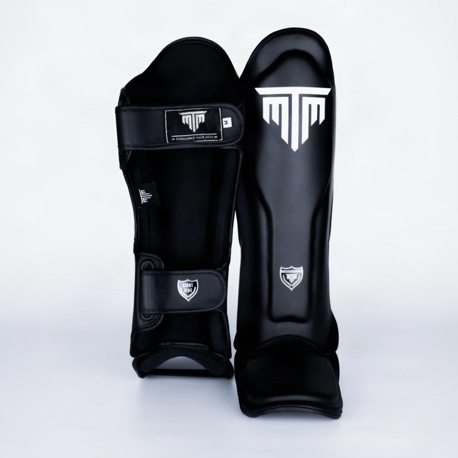 Close-up of MTM Sport VX Shin Guards in black, showing texture and branding